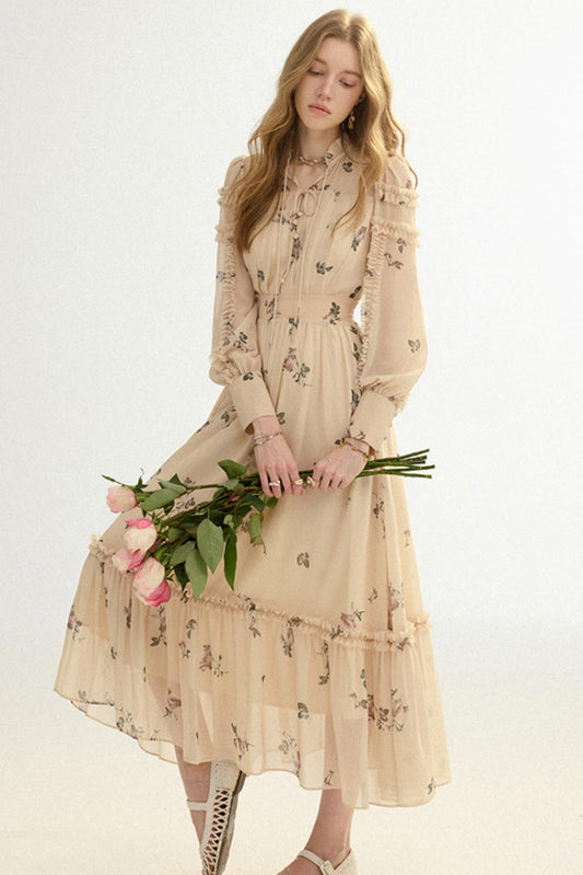 Woman in a beige floral dress holding flowers on a white background
