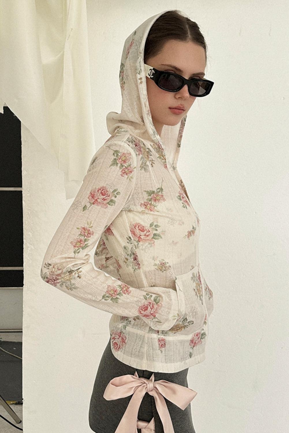 Woman wearing a floral hoodie with a plain background