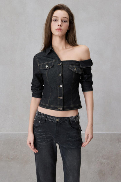 Woman wearing a black denim jacket and jeans against a gray background