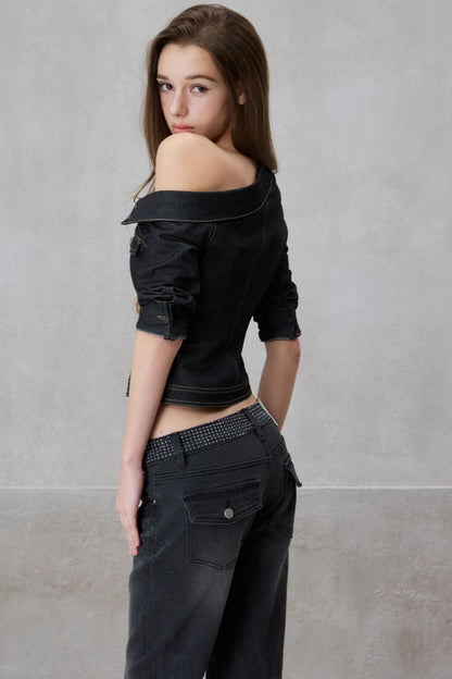 Woman wearing a black off-shoulder top and black pants against a gray background