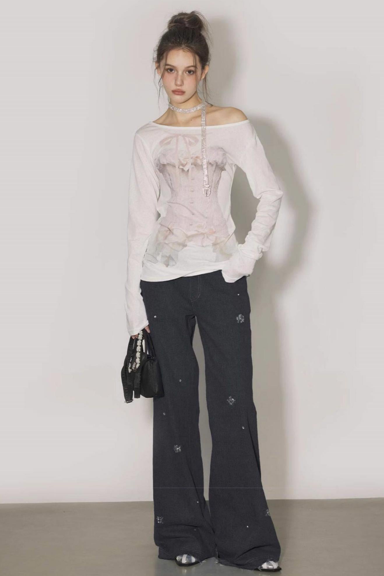 Woman wearing a light pink off-shoulder top and dark pants against a plain background