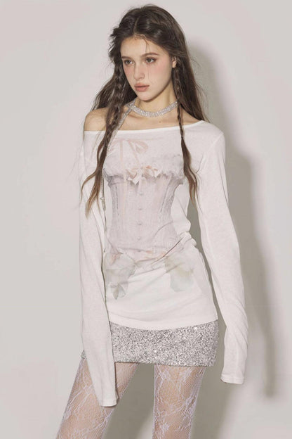 Woman wearing a white off-shoulder top with floral patterns and a silver skirt against a plain background