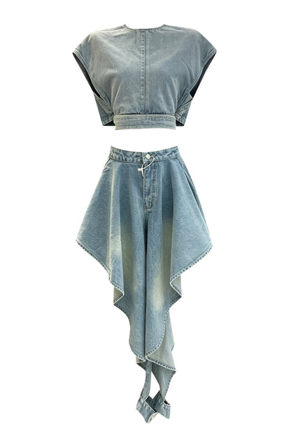 A two-piece light blue denim set featuring a short-sleeve crop top with a button-down front and a matching high-waisted asymmetrical mini skirt with rolled hems.