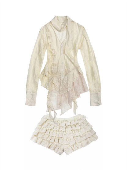 A cream-colored two-piece outfit featuring a long-sleeve ruffled blouse and matching ruffled shorts, displayed against a solid white background.