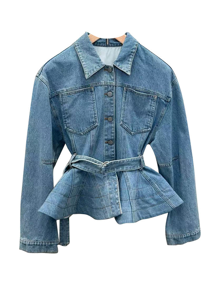 A light blue denim jacket with a pointed collar, button front, chest flap pockets, and a matching self-tie belt, displayed on a wooden hanger against a plain white background.