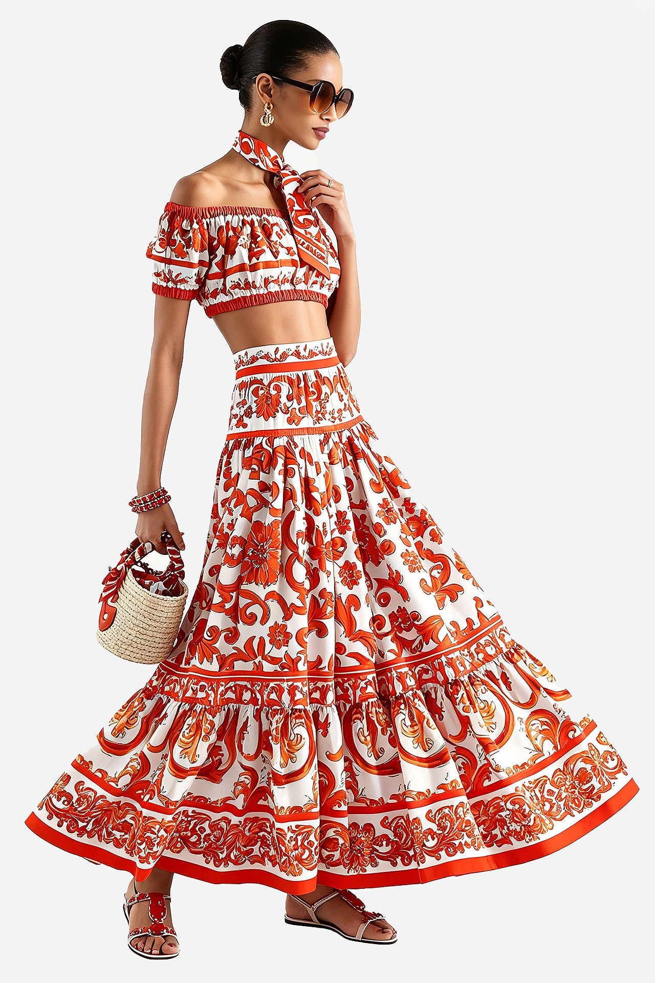 A woman modeling a matching off-the-shoulder crop top and tiered maxi skirt set in a red and white floral print, styled with a matching neck scarf, sunglasses, a woven straw bag, and brown sandals against a light gray background.