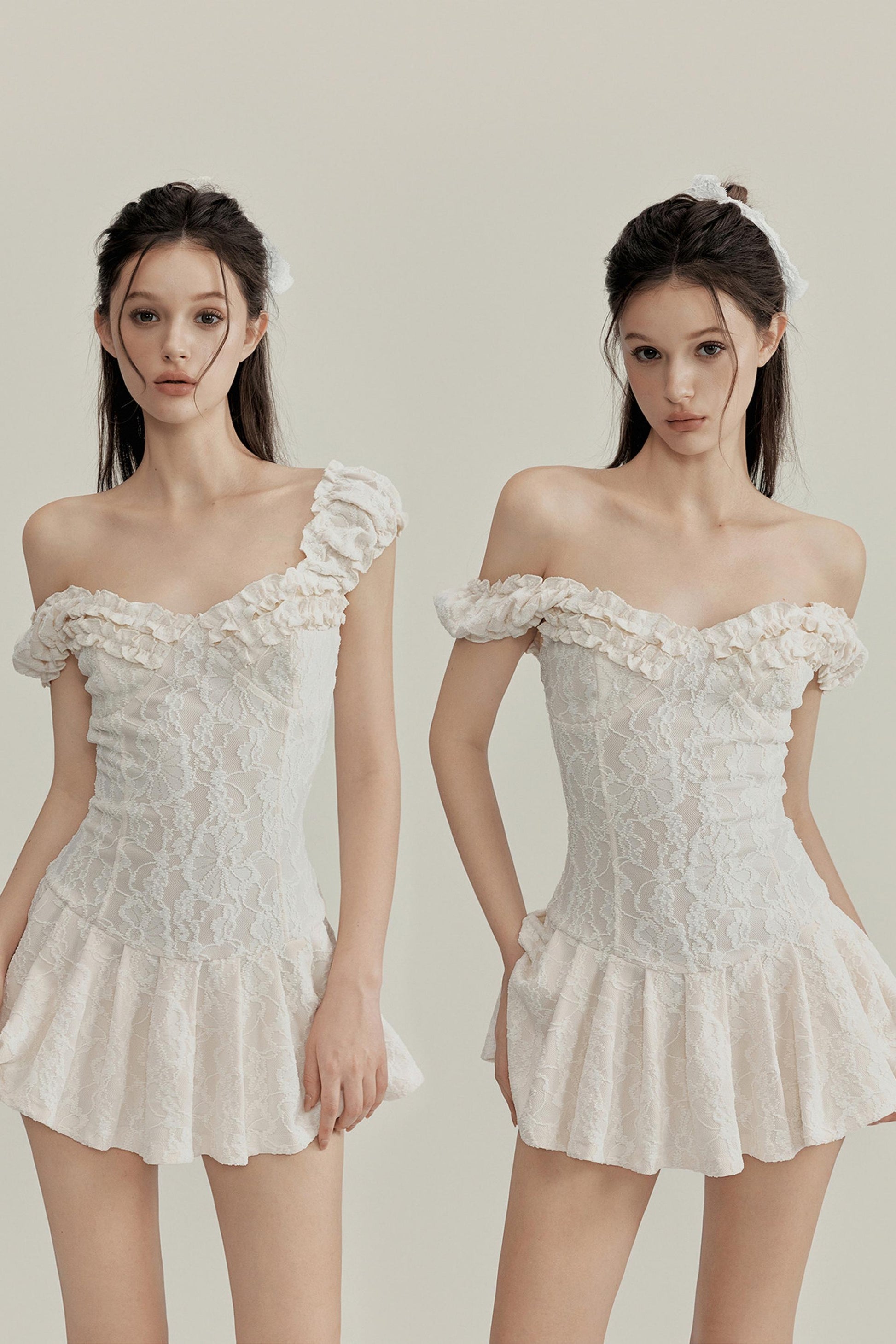 Two women wearing off-shoulder lace dresses on a plain background