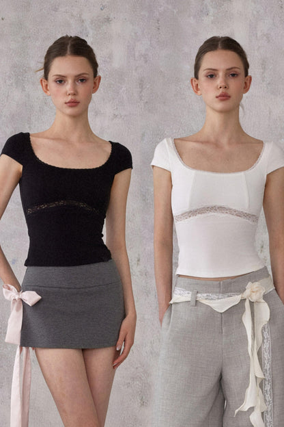 Two models wearing black and white tops with gray skirts against a gray background