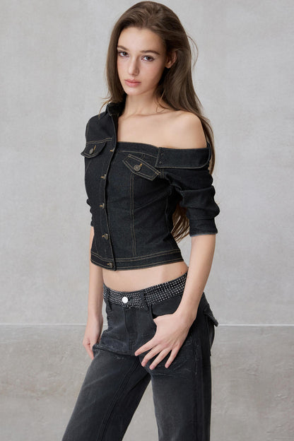 Woman wearing a black denim jacket and pants against a gray background