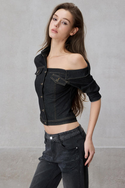 Woman wearing a black denim jacket and pants against a gray background