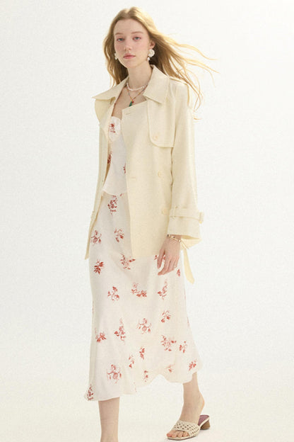 A woman modeling a cream-colored long-sleeve button-up shirt jacket over a matching cream floral midi dress, paired with beige strappy heeled sandals against a plain white studio background.
