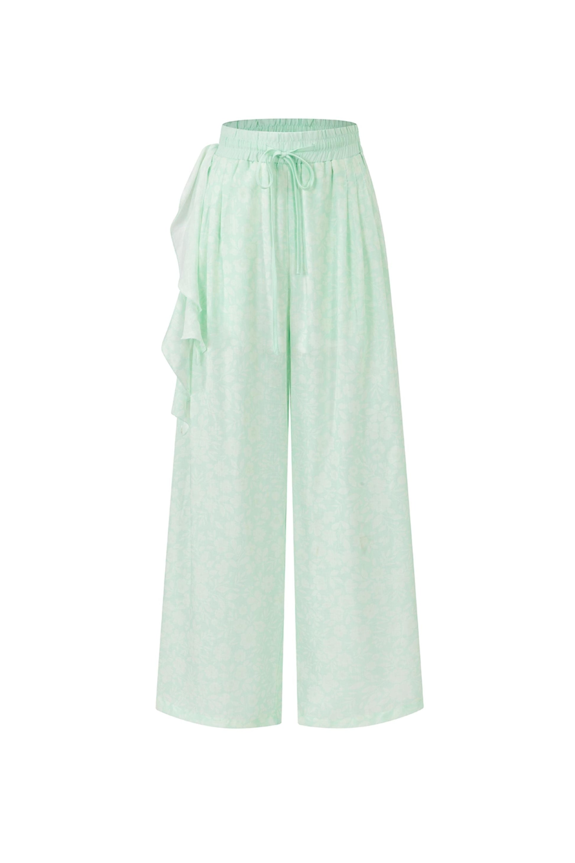 Light mint green wide-leg pants with a drawstring waist and side ruffle detail, shown against a plain white background.