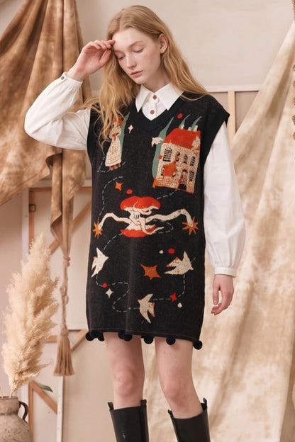 A woman modeling a black knit sweater vest with whimsical, colorful embroidered motifs including a skeleton, a house, stars, and birds, worn over a white collared shirt and black boots.