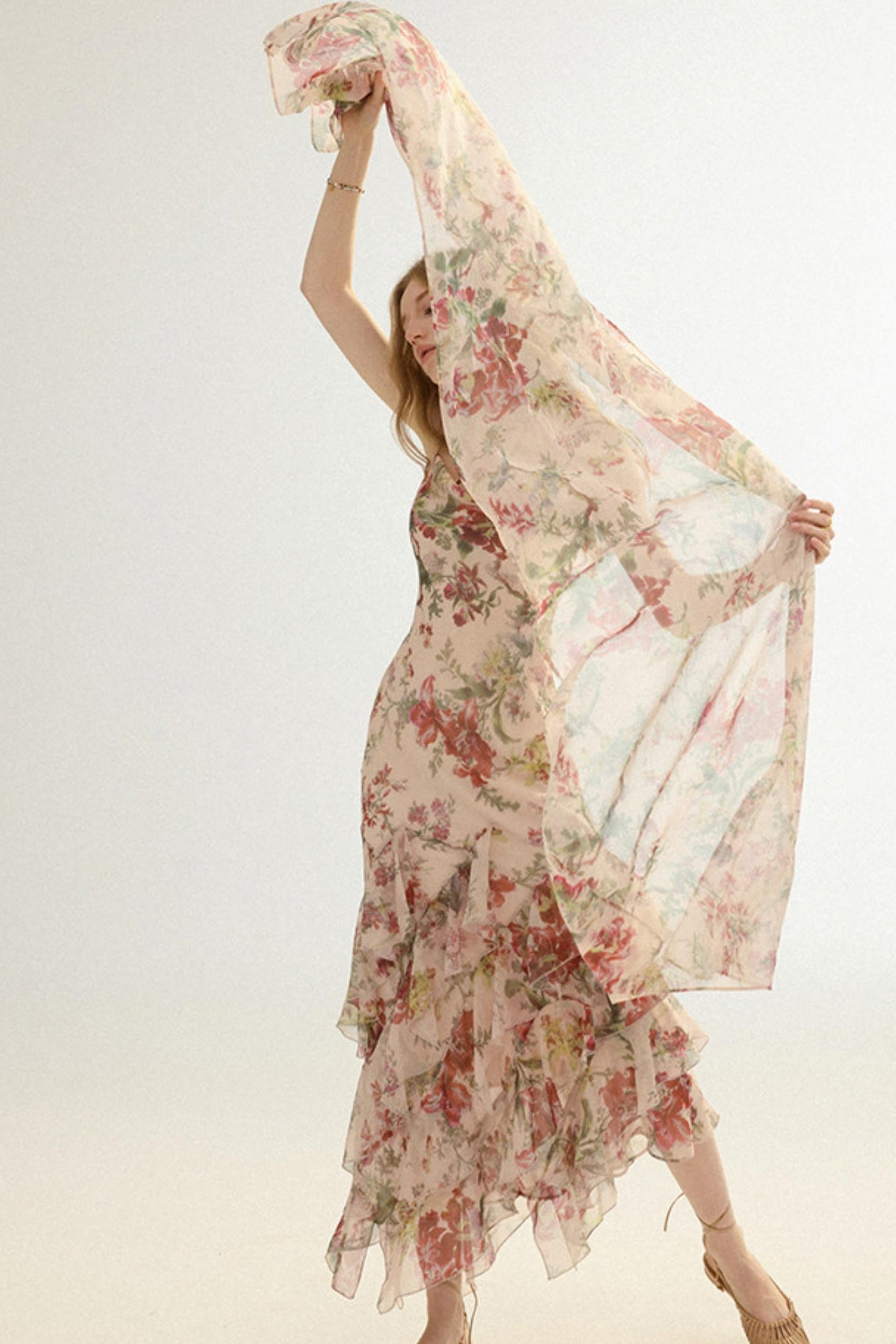 Woman holding a floral scarf with a plain background