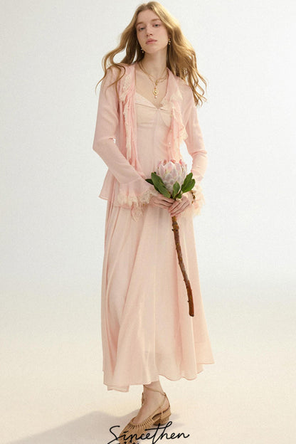 Woman in a light pink dress holding a flower against a white background