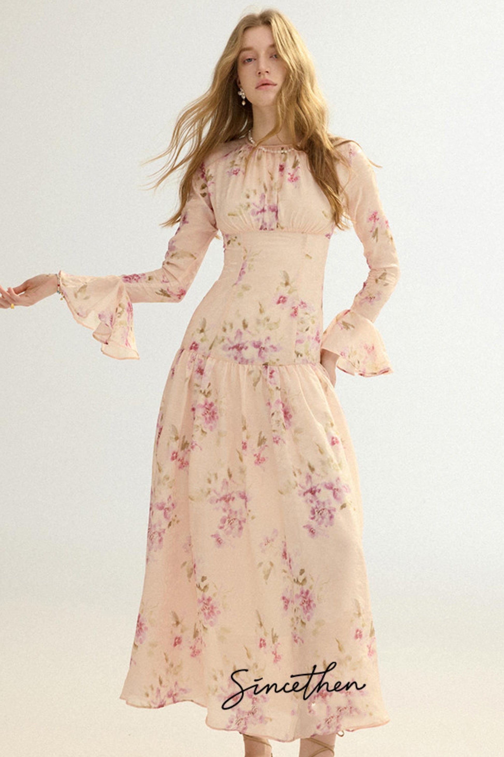 Woman wearing a floral dress with 'Sincethen' branding on a light background