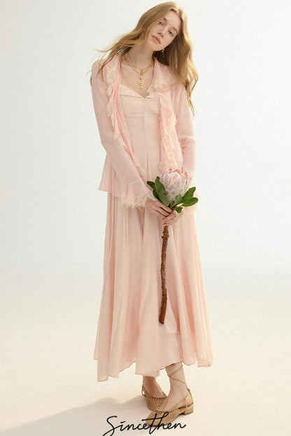 Woman in a light pink dress holding a flower against a white background