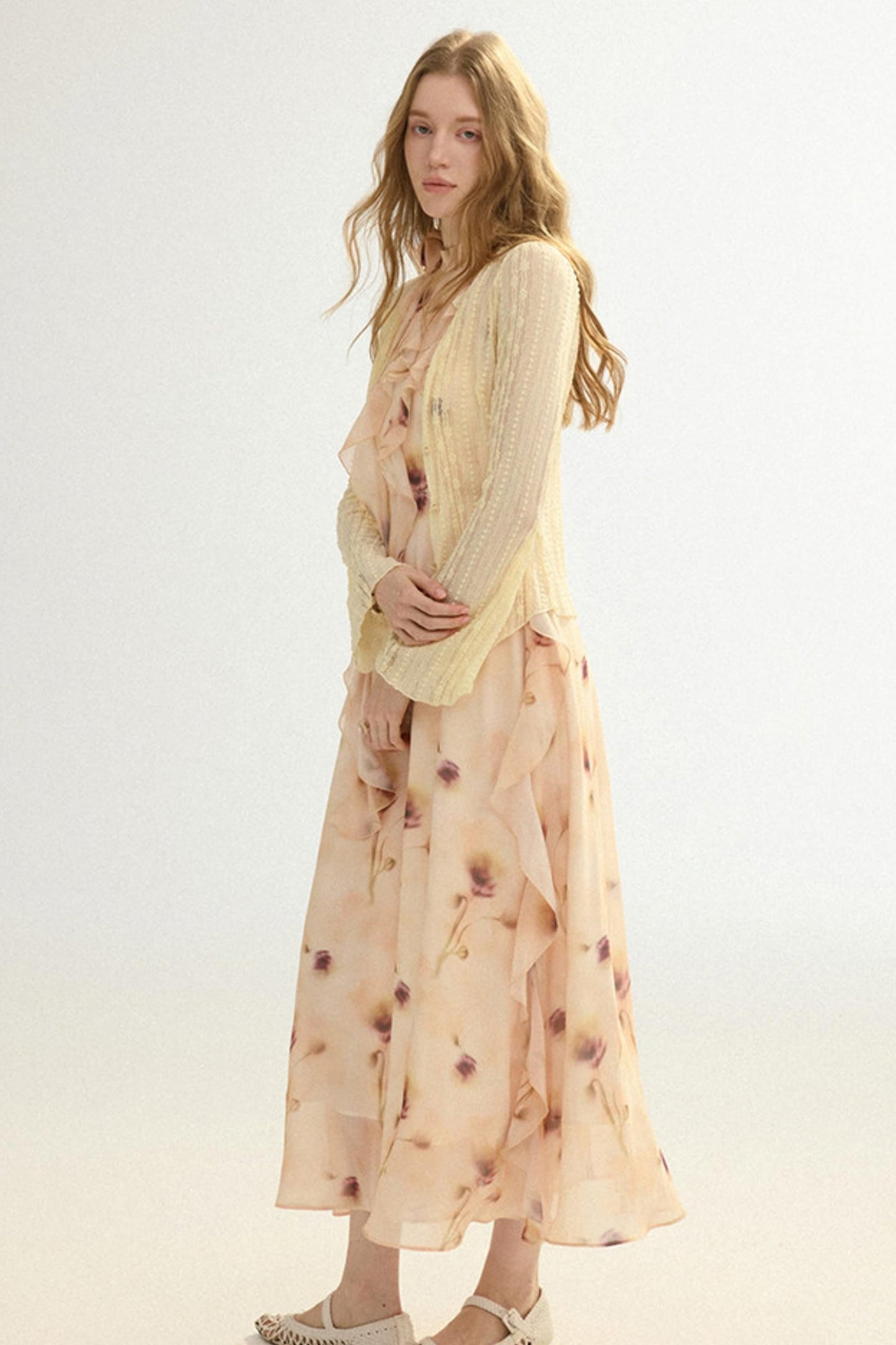 Woman wearing a light-colored outfit with a floral pattern on a white background