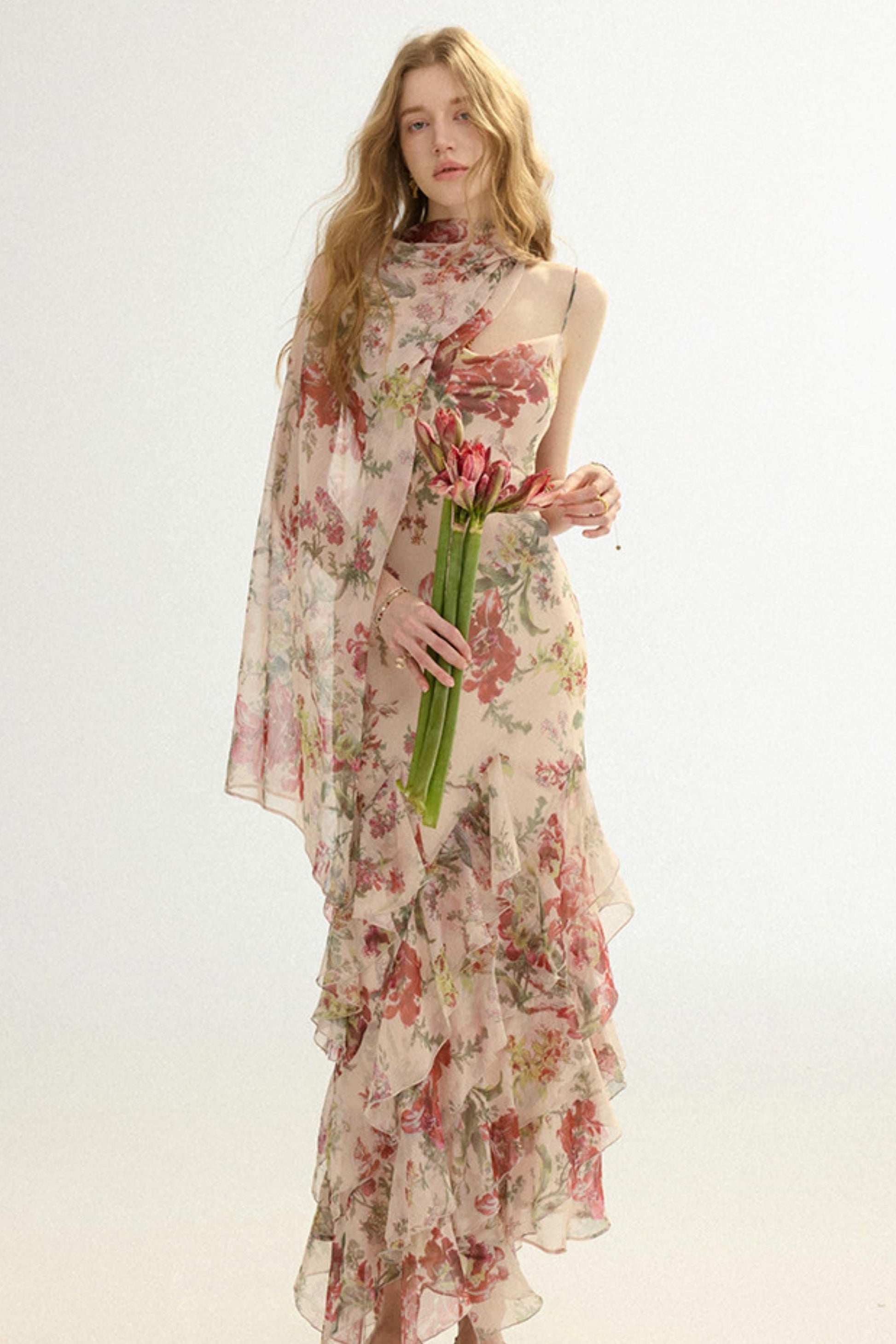 Woman wearing a floral dress holding tulips on a white background
