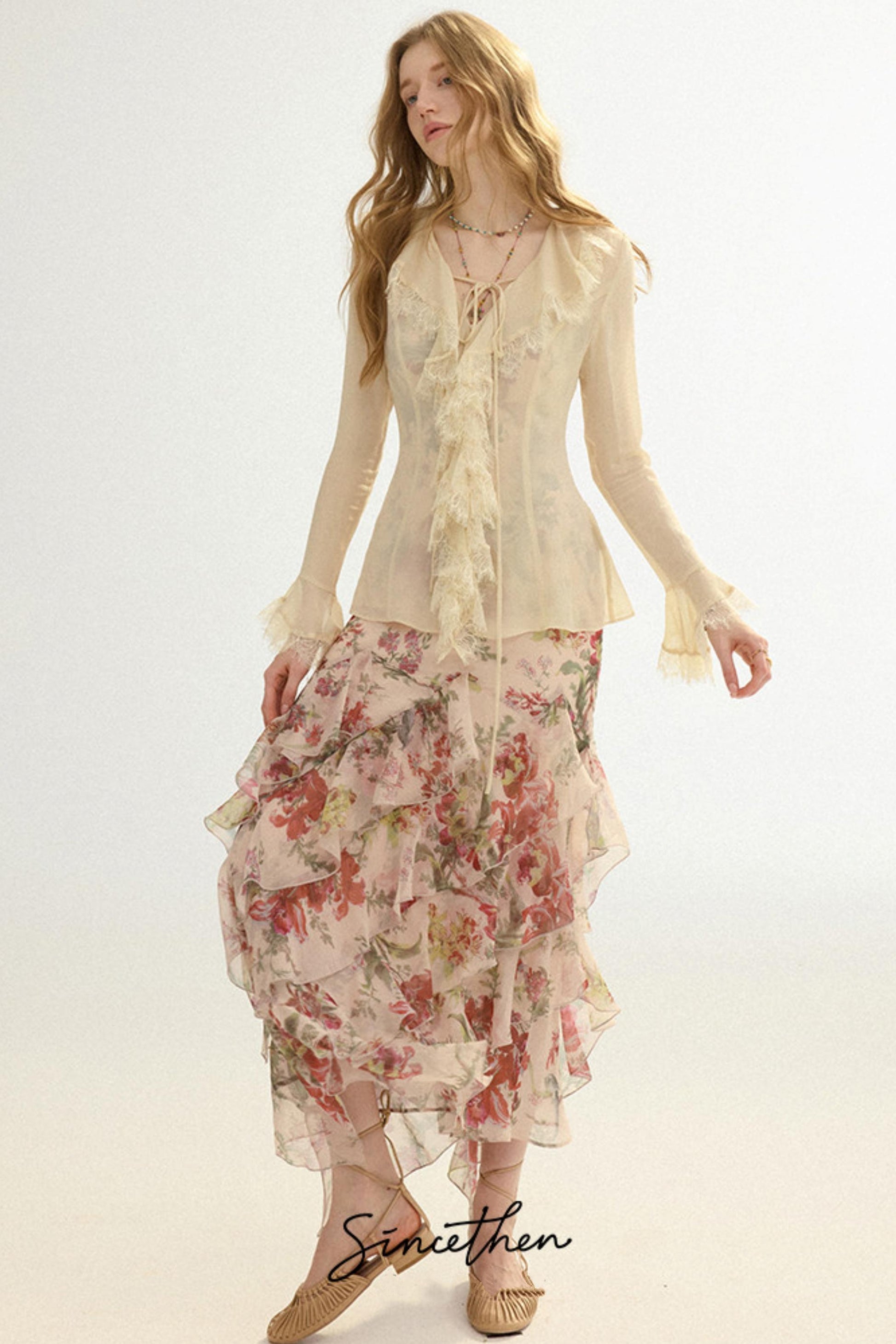 Woman wearing a floral dress and beige top on a white background