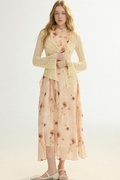 Woman wearing a light yellow cardigan over a floral dress on a white background