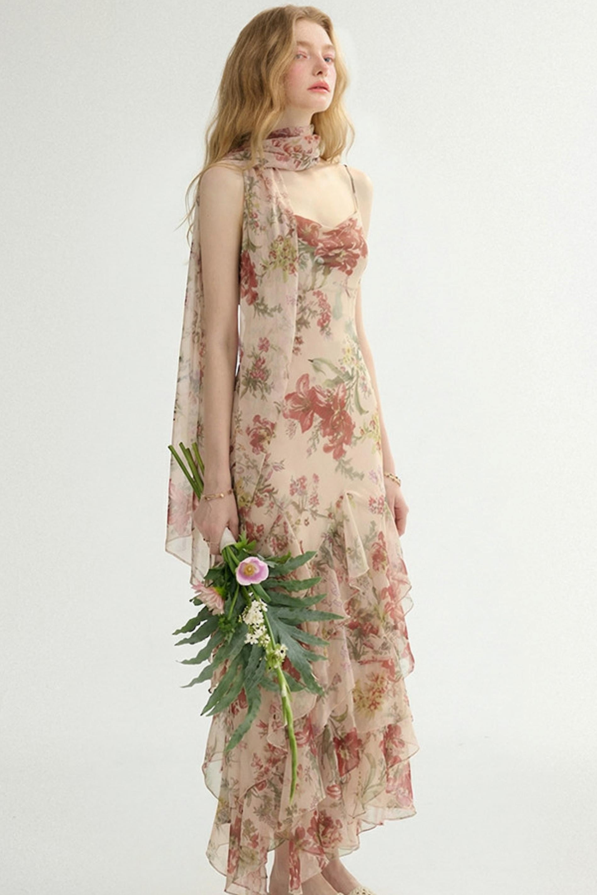 Woman wearing a floral dress holding a bouquet on a white background