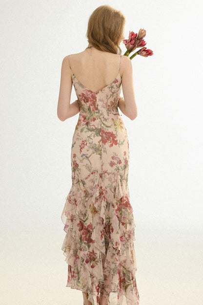 Woman wearing a floral dress holding flowers against a plain background