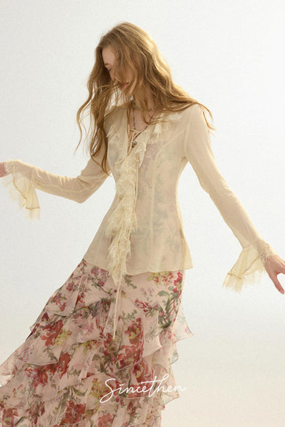 Woman wearing a floral dress with a sheer top against a light background