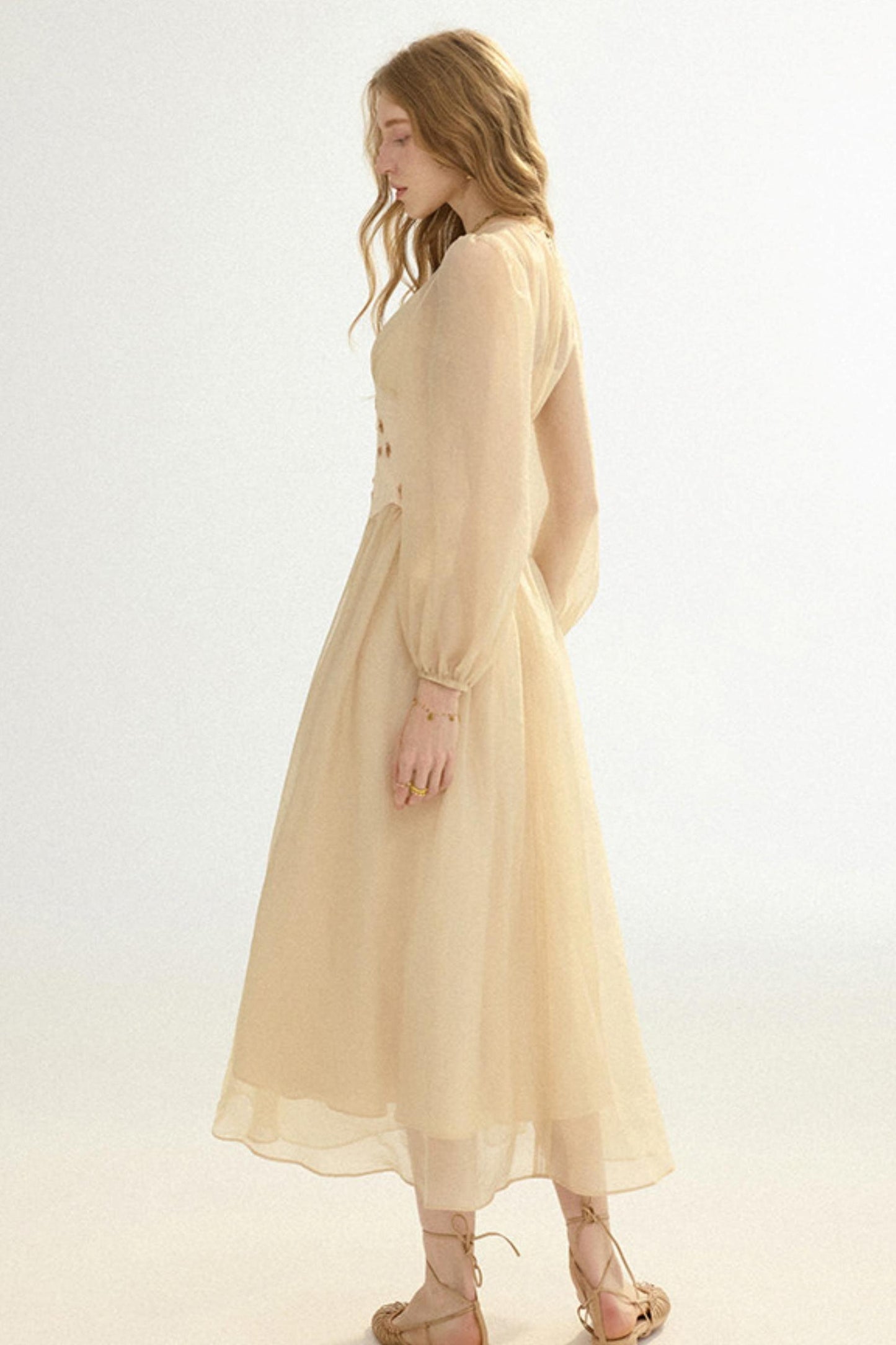 Woman wearing a beige dress on a white background