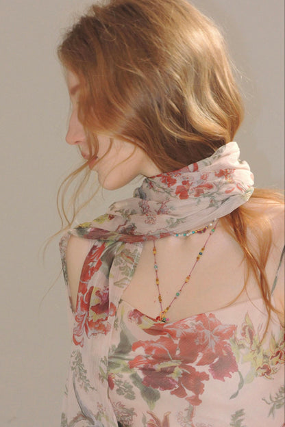 Woman wearing a floral scarf with a neutral background
