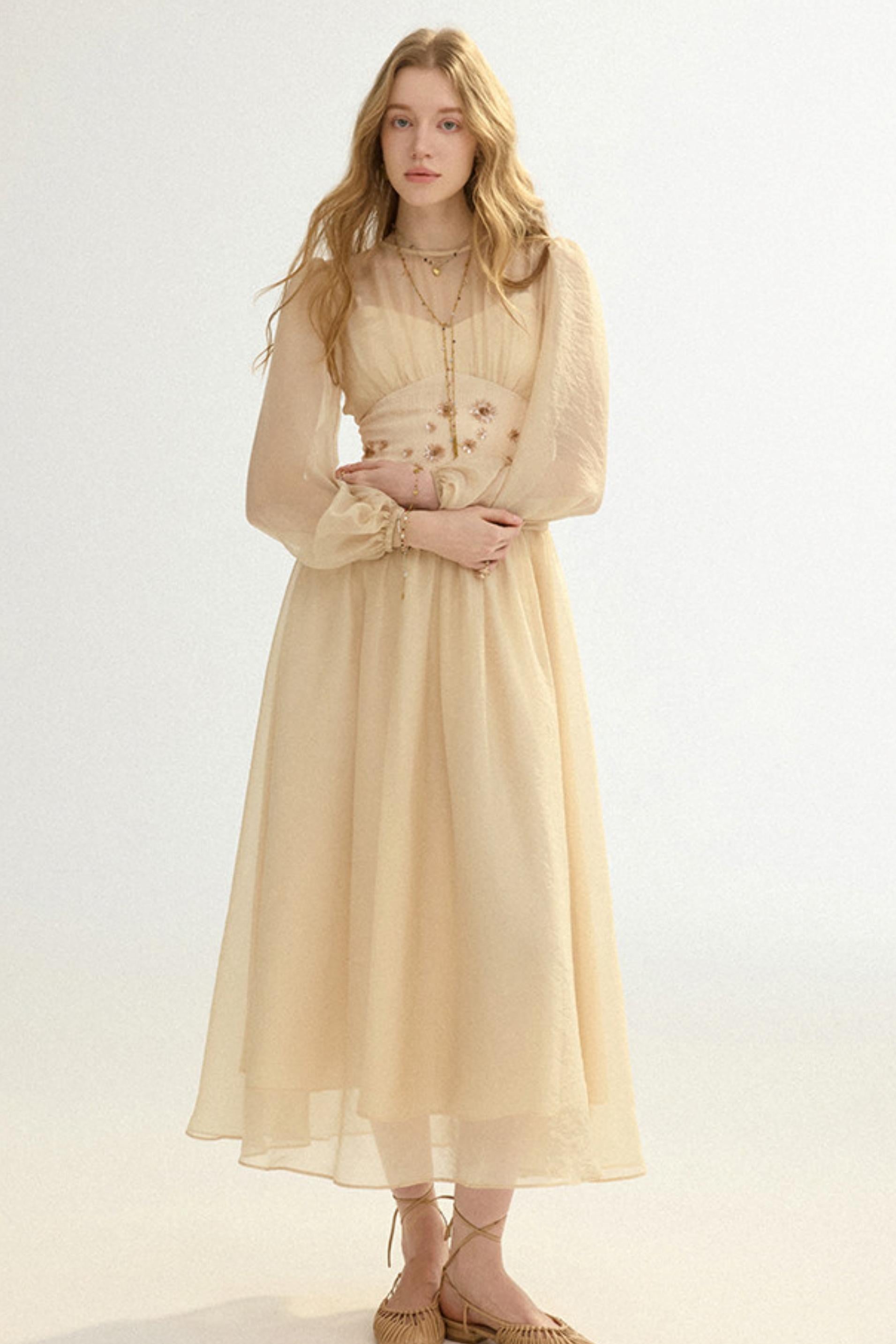 Woman wearing a beige dress with long sleeves on a white background