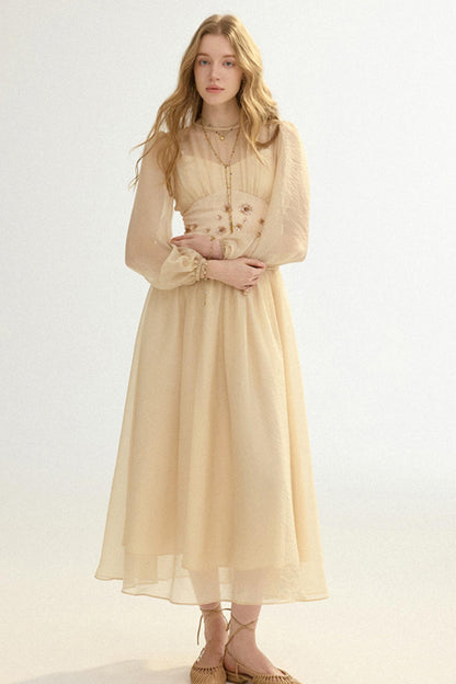 Woman wearing a beige dress with long sleeves on a white background