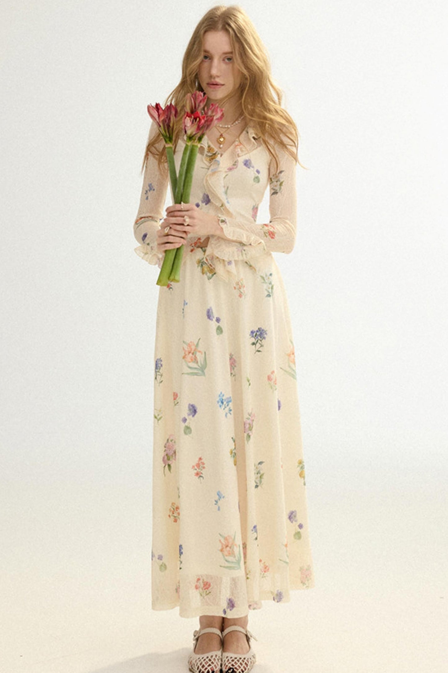 Woman in a floral dress holding tulips against a white background