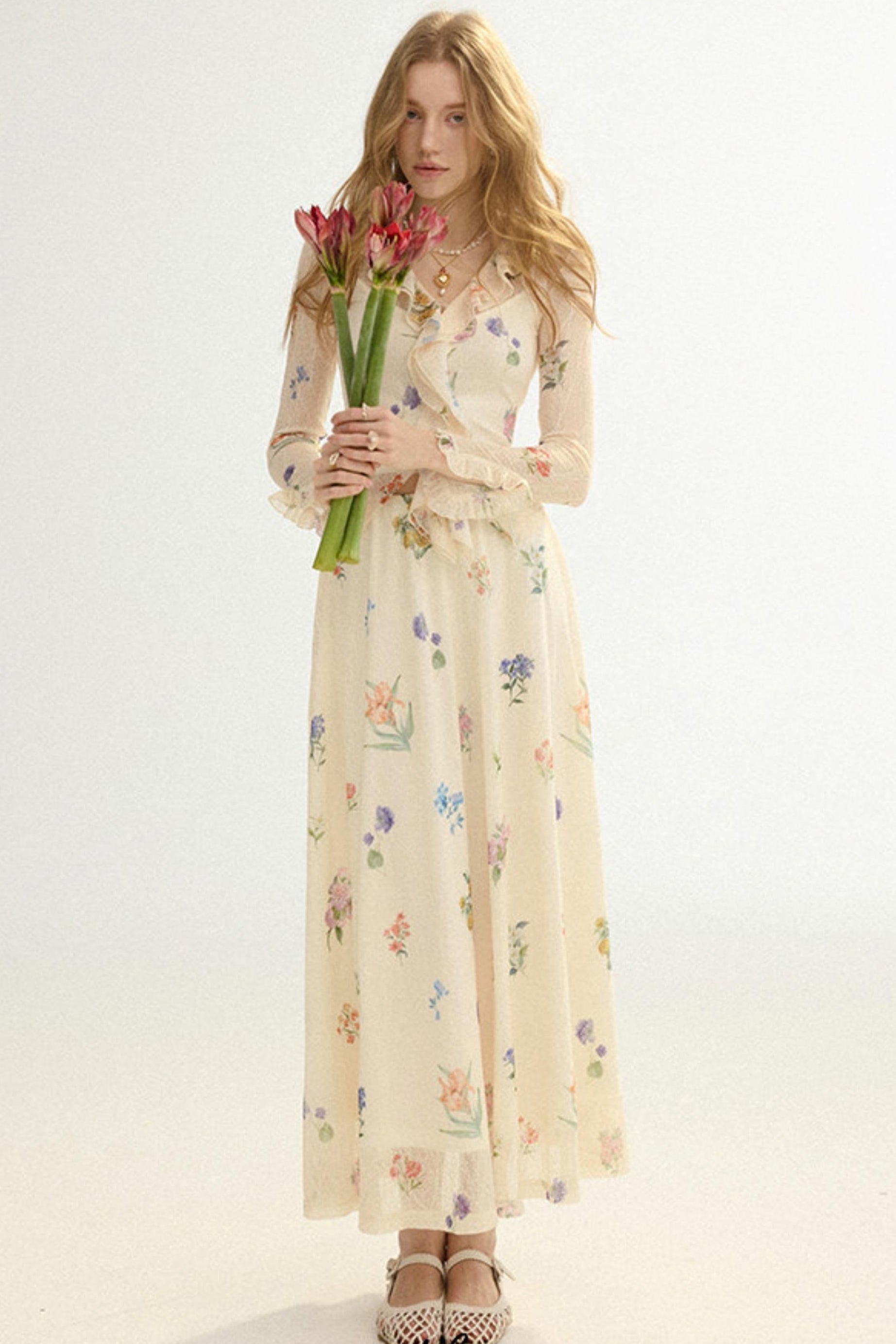 Woman in a floral dress holding tulips against a white background