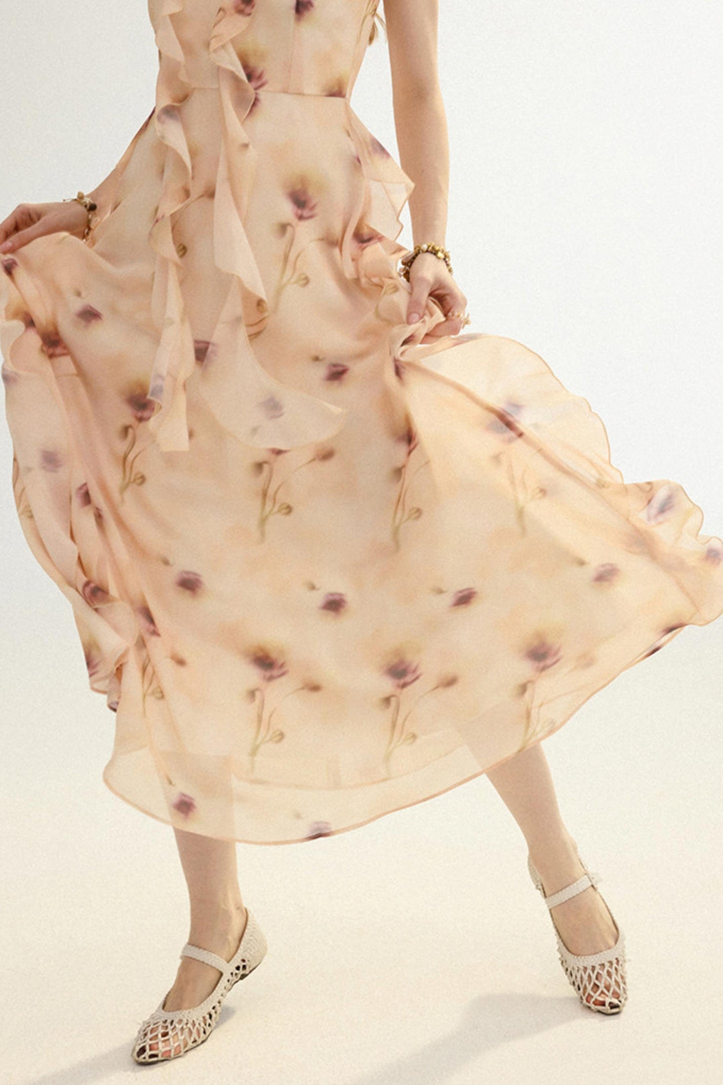 Woman wearing a beige floral dress with a plain background