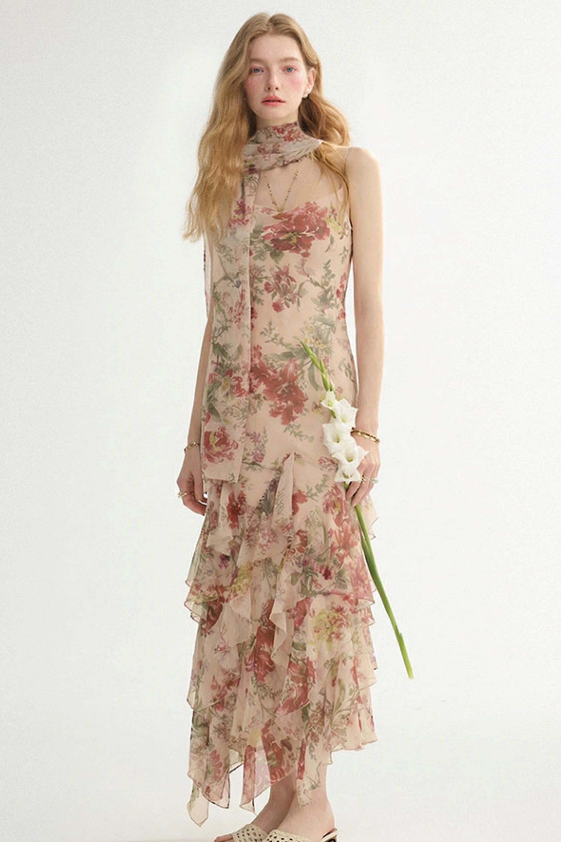 Woman wearing a floral dress holding a flower on a white background