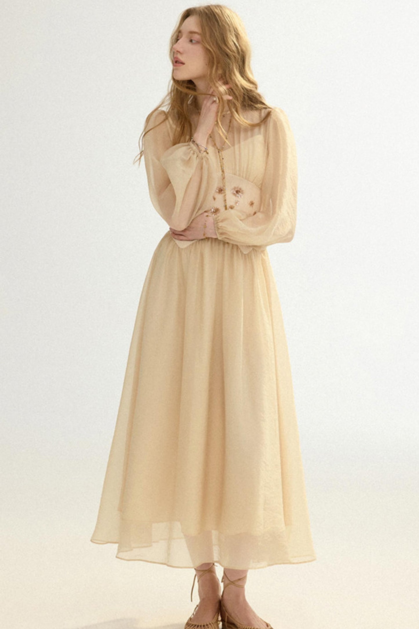 Woman wearing a beige dress against a white background
